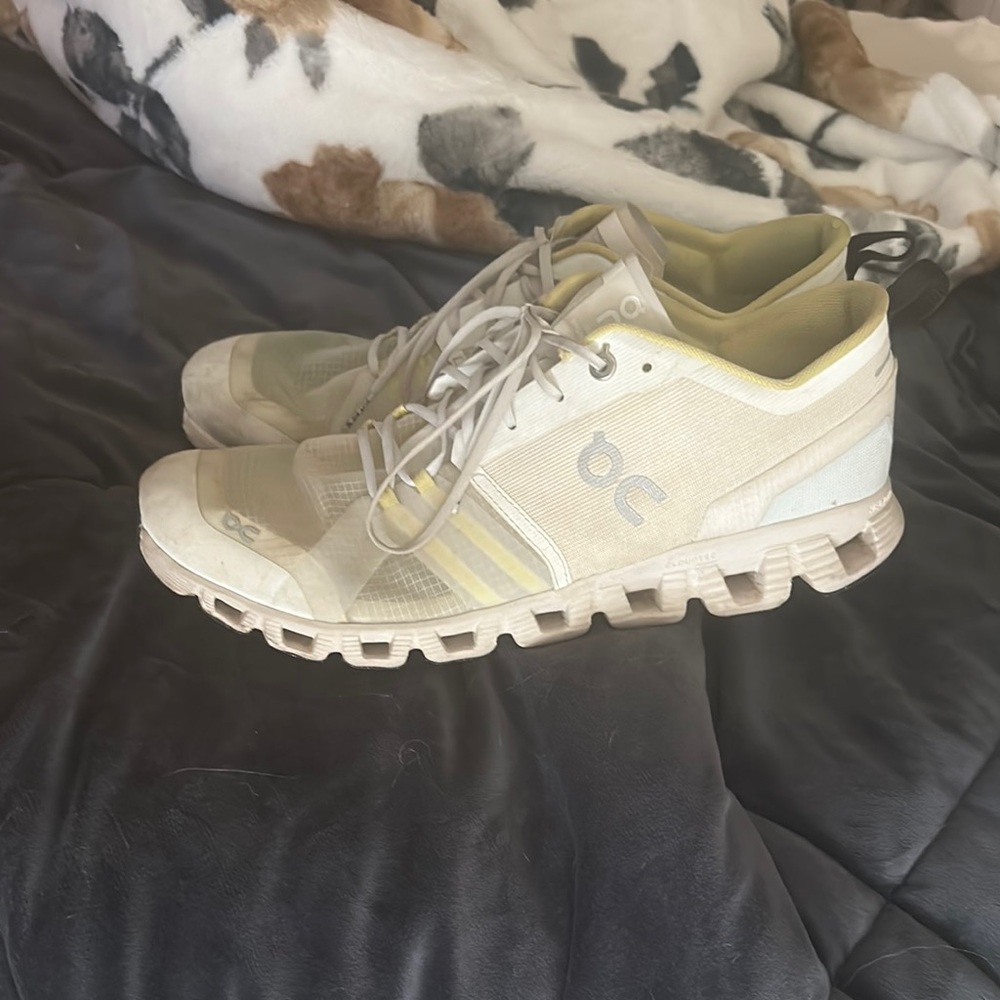 On Running Cream and Yellow Athletic Shoes